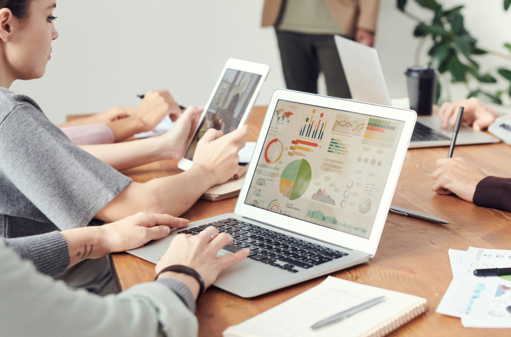 Team analyzing property data and reports using cloud-based real estate software during a collaborative meeting.